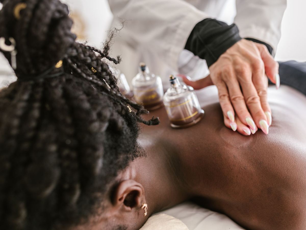 Une séance de hijama, ventouses posées sur le dos et mains du praticien