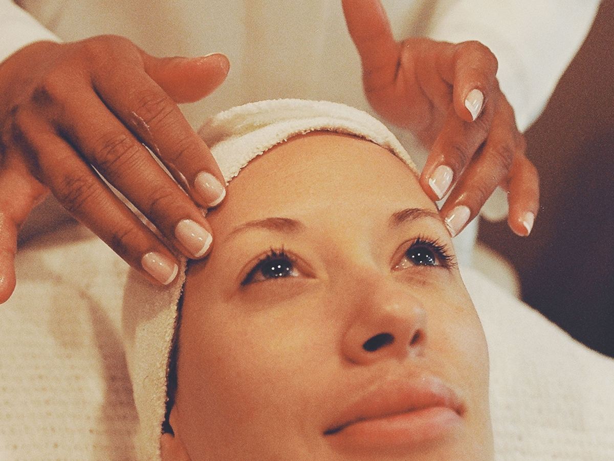 Un soin du visage personnalisé, les mains de la praticienne posées de part et d'autre du front